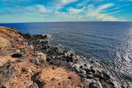 在希腊圣托里尼岛红海滩火山灰沙岩层上观看 晴天 海洋背景图片