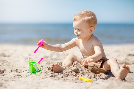 沙滩桶小小孩在沙滩上造沙城堡背景
