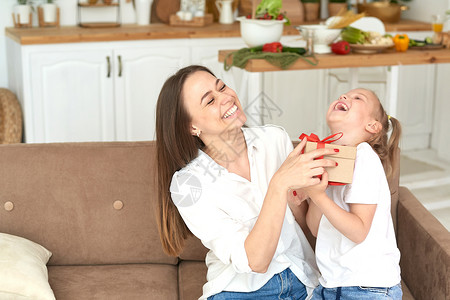 一起来鬼混幸福的女儿和母亲对礼物欢欣鼓舞 并一起欢笑背景