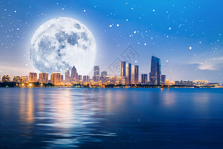 夜晚中秋城市上空的圆月设计图片