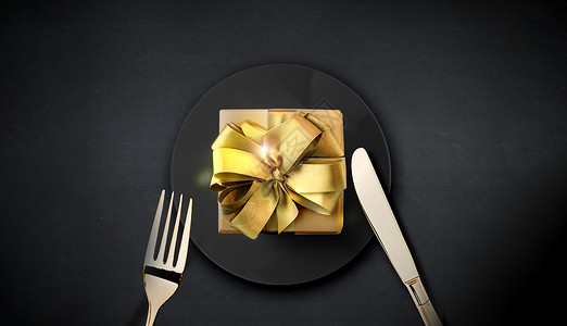餐叉金色不锈钢餐桌上的礼盒设计图片