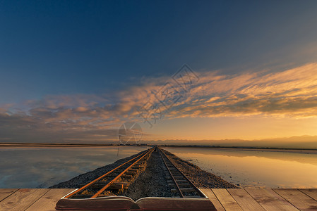 夕阳湖边超现实主义的铁轨设计图片