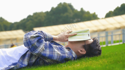 草头圈子男青年户外看书休息GIF高清图片