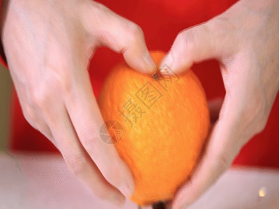 手里拿着橘子实拍手剥橘子GIF高清图片