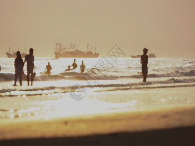 一群背影黄昏海边人群游玩GIF高清图片