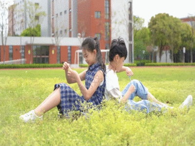 孩子们坐在草地上吹泡泡GIF图片