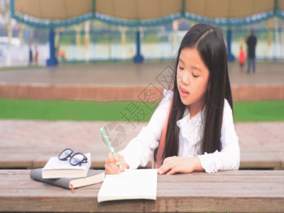 小学生写字孩子趴在桌上写字GIF高清图片