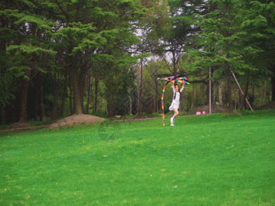 小女孩拿着风筝在草地上跑GIF图片