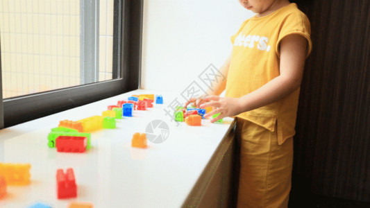 玩具收纳柜小女孩在玩积木益智游戏GIF高清图片