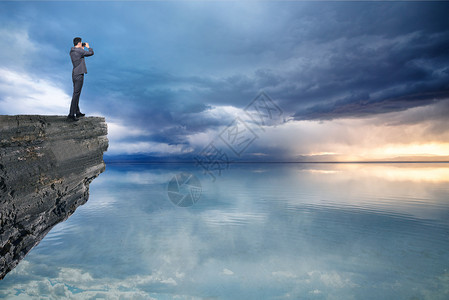乌云大海站在岩石上展望未来设计图片