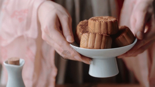 白色巧克力蛋糕穿着汉服用手放下一盘月饼GIF高清图片