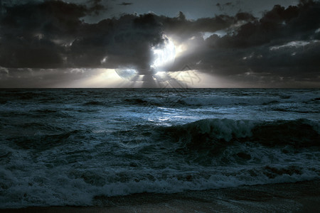由月亮云彩光束海浪和海浪组成的图片