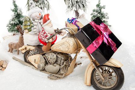 圣诞老人和一个雪人正在他们的摩托车上送图片