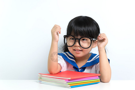 小亚洲女孩戴着带书本的眼镜图片