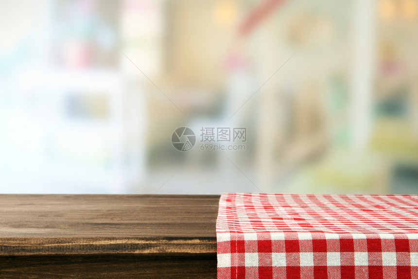 有餐巾和浅色背景的空木桌图片