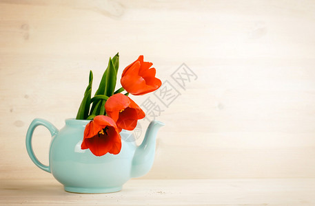 复古木质背景茶壶中的春郁金香花束背景图片