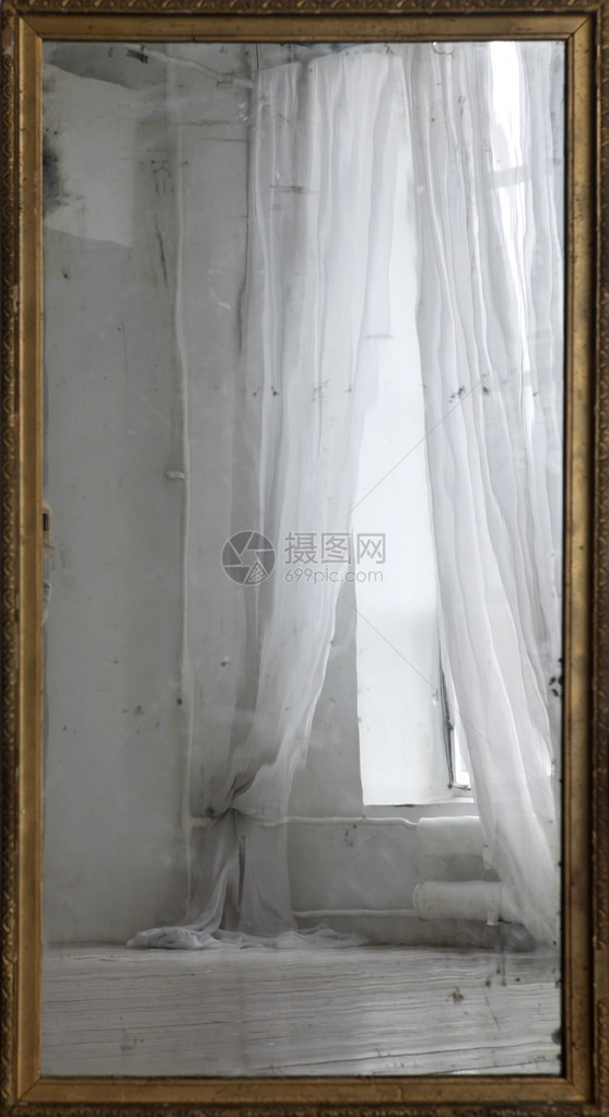 旧镜子中带窗帘的窗户的倒影图片