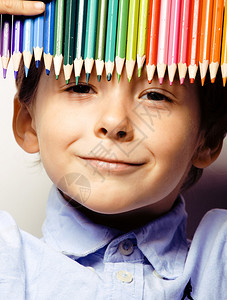 可爱的小可爱男孩带着彩色铅笔紧地微笑着教育图片
