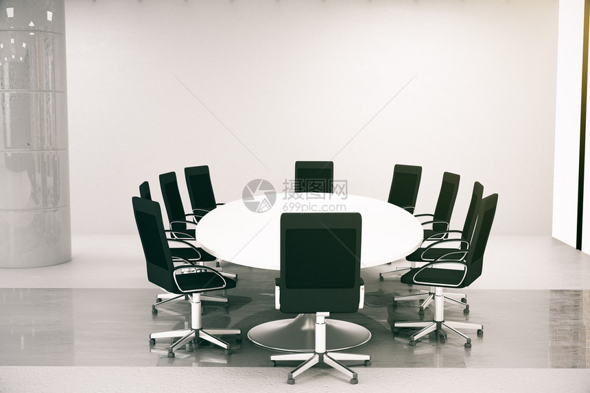 室内有圆桌椅子的亮混凝土会议室侧面图片