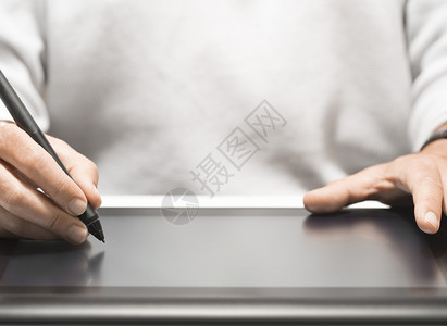 关闭拿着电子触笔的平面设计师的手背景与文本的可用空图片
