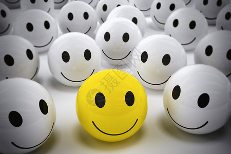 3D带着笑脸的黄色球与如此众多的白微笑球快乐的领导者图片