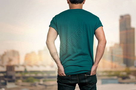 在抽象模糊的城市景观照片上穿着空白T恤的男人有太阳背图片