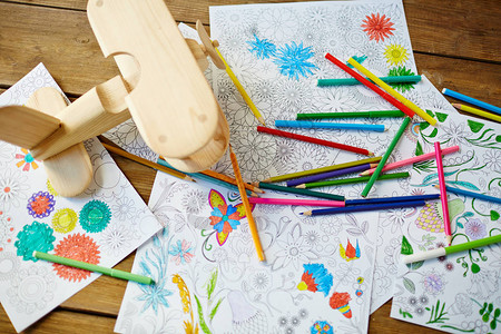 木制桌上彩色书籍飞机玩具和铅图片