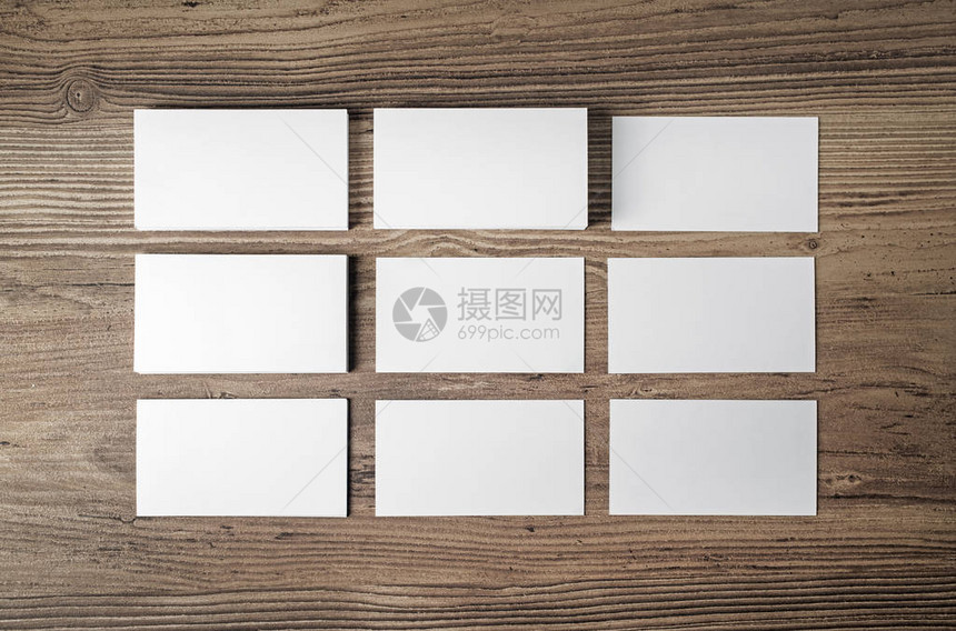 木桌背景上的许多空白名片用于放置您的设计的空白文书工作模板图片