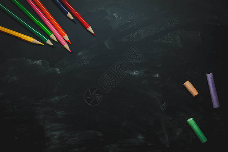 顶视图平将彩色铅笔和彩色粉笔板放在黑桌木制背景上免费创意设计字或文本的空间教育或回到学校概念背景图片