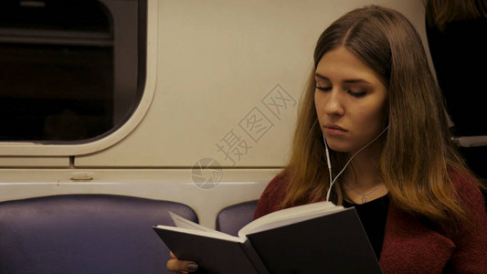 美丽的女孩在地铁的火车上看书十几岁的女孩在火车或地铁车厢图片