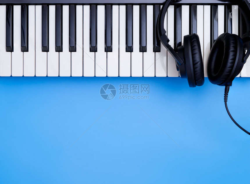 在蓝色复制空间的音乐键盘上播放音乐耳机图片