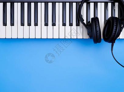 在蓝色复制空间的音乐键盘上播放音乐耳机背景图片