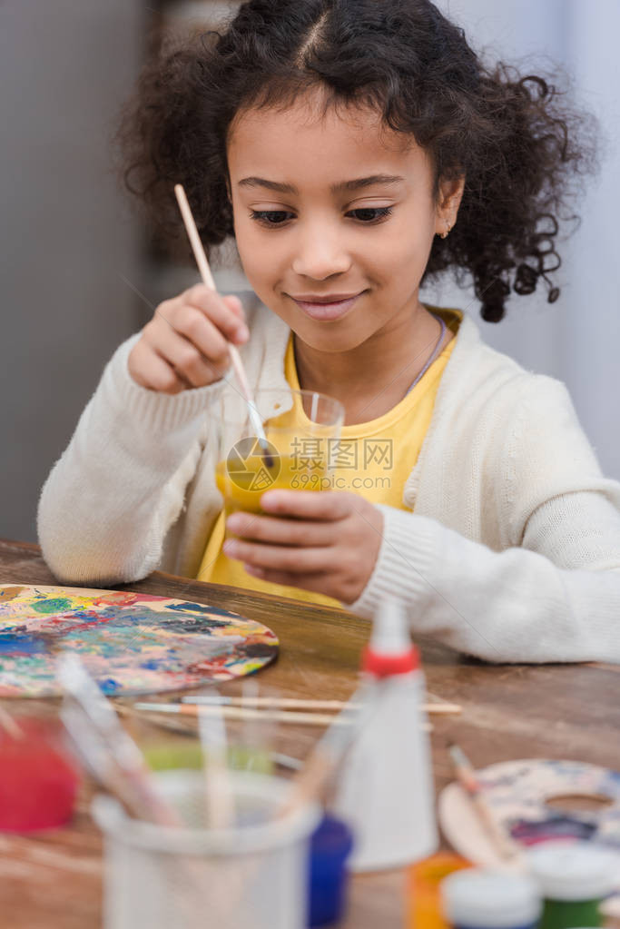 AfricanAmericankids用涂漆的玻璃刷在玻璃上图片