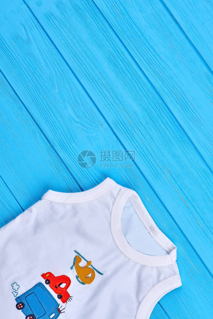 婴儿男孩T恤和复制空间婴儿男孩围着颈部蓝木头背景的图片