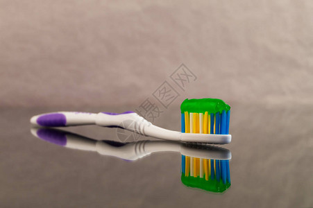 一张牙膏绿色的牙刷在灰色抽象背景和图片