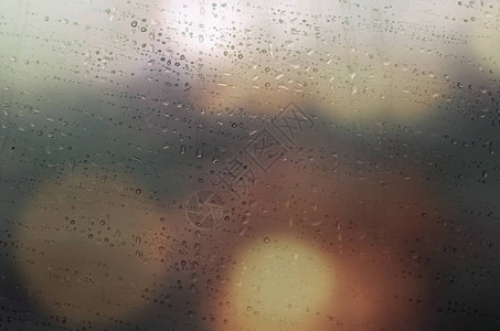 窗上的雨滴与抽象的灯光图片