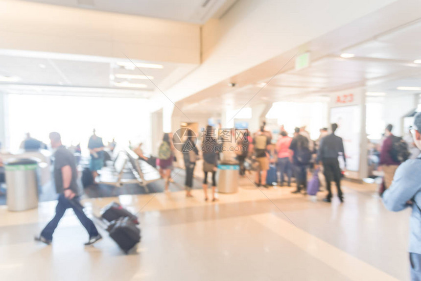 在美国德克萨斯州达拉斯沃思堡机场等候区站着和坐在行李箱上的模糊乘客模糊的不同人群排队作为抽象的交图片