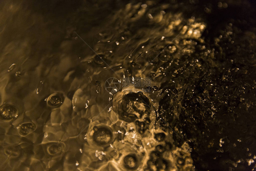 抽象的金色水流在盆地图片