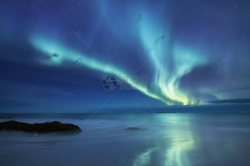 挪威罗弗敦群岛上的北极光海洋上空的绿色北极光与极光的夜空夜间冬季景观与极光和水面上的反射挪图片