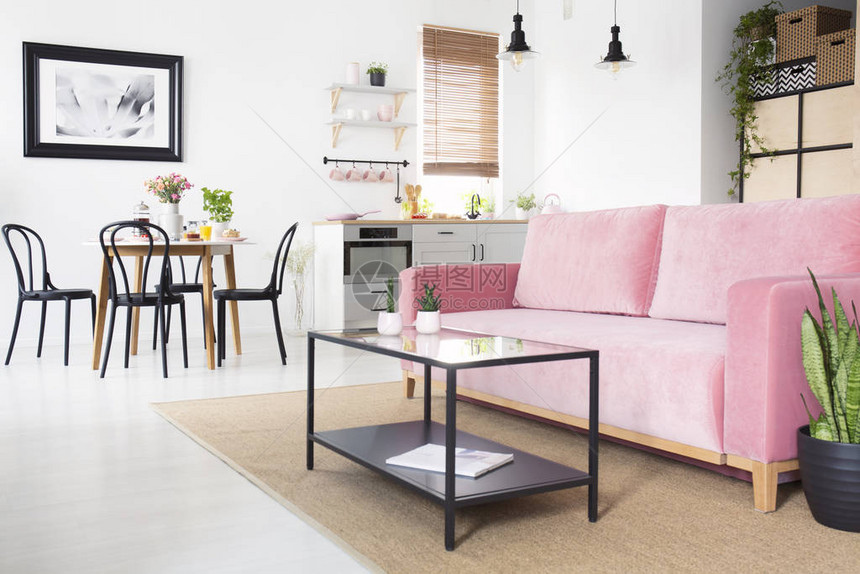 粉色沙发前的黑桌图片