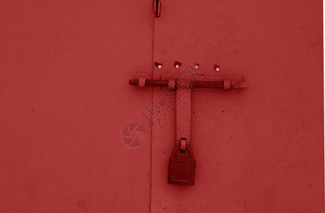 红色金属门上的旧挂锁抽象背景和纹理图片