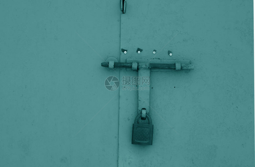 青色金属门上的旧挂锁抽象背景和纹理图片