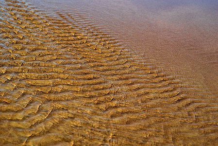 天然地貌背景中带有水波纹的沙底表面抽象浮化纹理图片