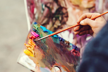 艺术家在调色板上刷混合色油画宏观艺术家的调色板用画笔调色板艺术家画一幅油画图片