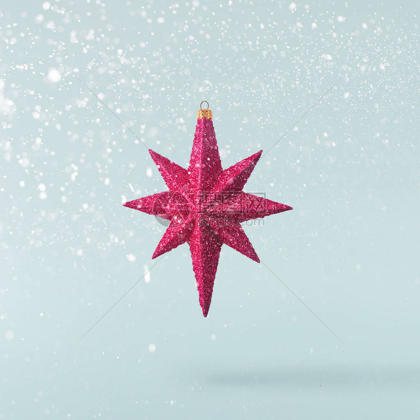 圣诞节的概念创造圣诞节概念由落入空气中的红色明亮的星在蓝色背景图片