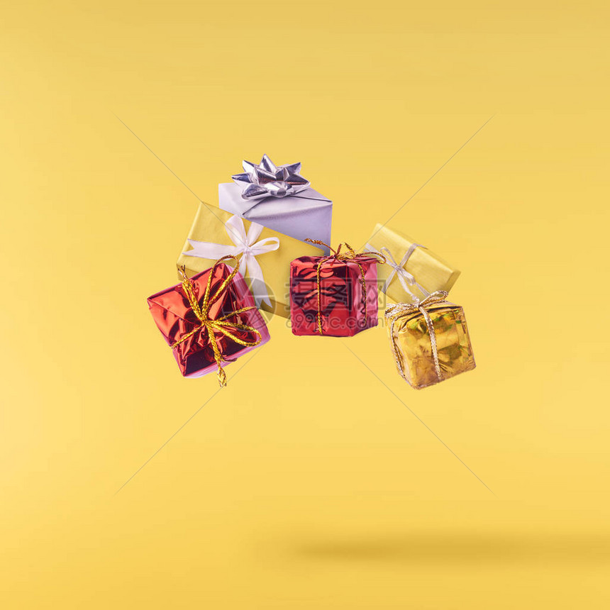 圣诞节的概念在黄色背景下坠入空中礼品盒中的创意圣诞构想图片