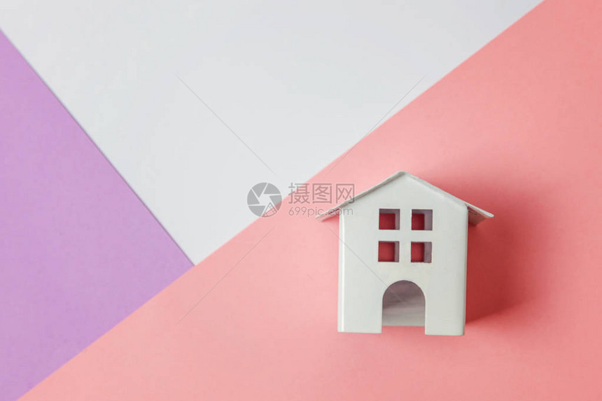 简单地设计与孤立在白色紫罗兰色粉彩色时尚几何背景上的微型白色玩具屋抵押财产保险梦想家园概念平躺顶图片