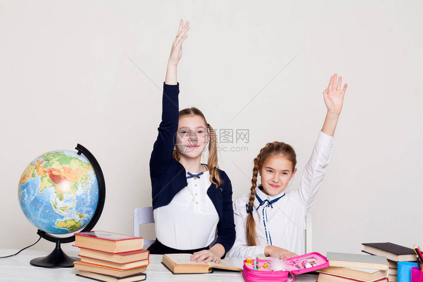 有两个女学生在课桌前的课室里用书本图片