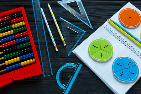 深色木制背景或桌子上的彩色数学分数孩子们有趣的数学教育图片