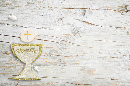 白色木质背景上的第一次圣餐邀请金银圣杯和鸽子图片